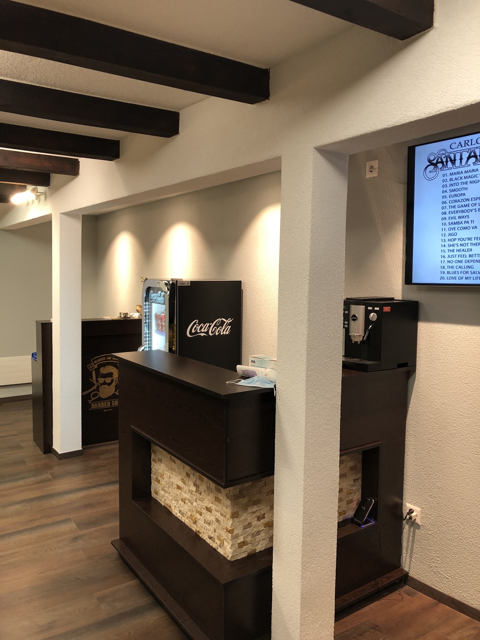 Coin accueil avec mini-frigo, machine à café et écran au mur