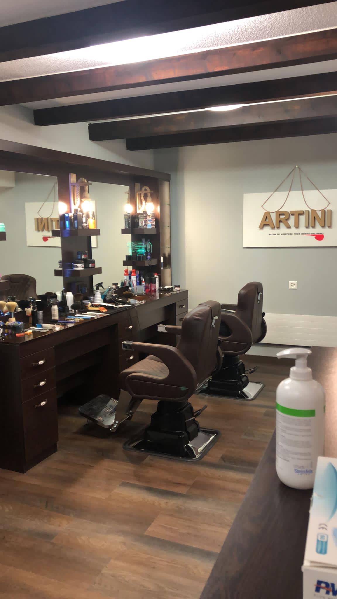 Fauteuils de barbier avec enseigne ARTINI et produits professionnels