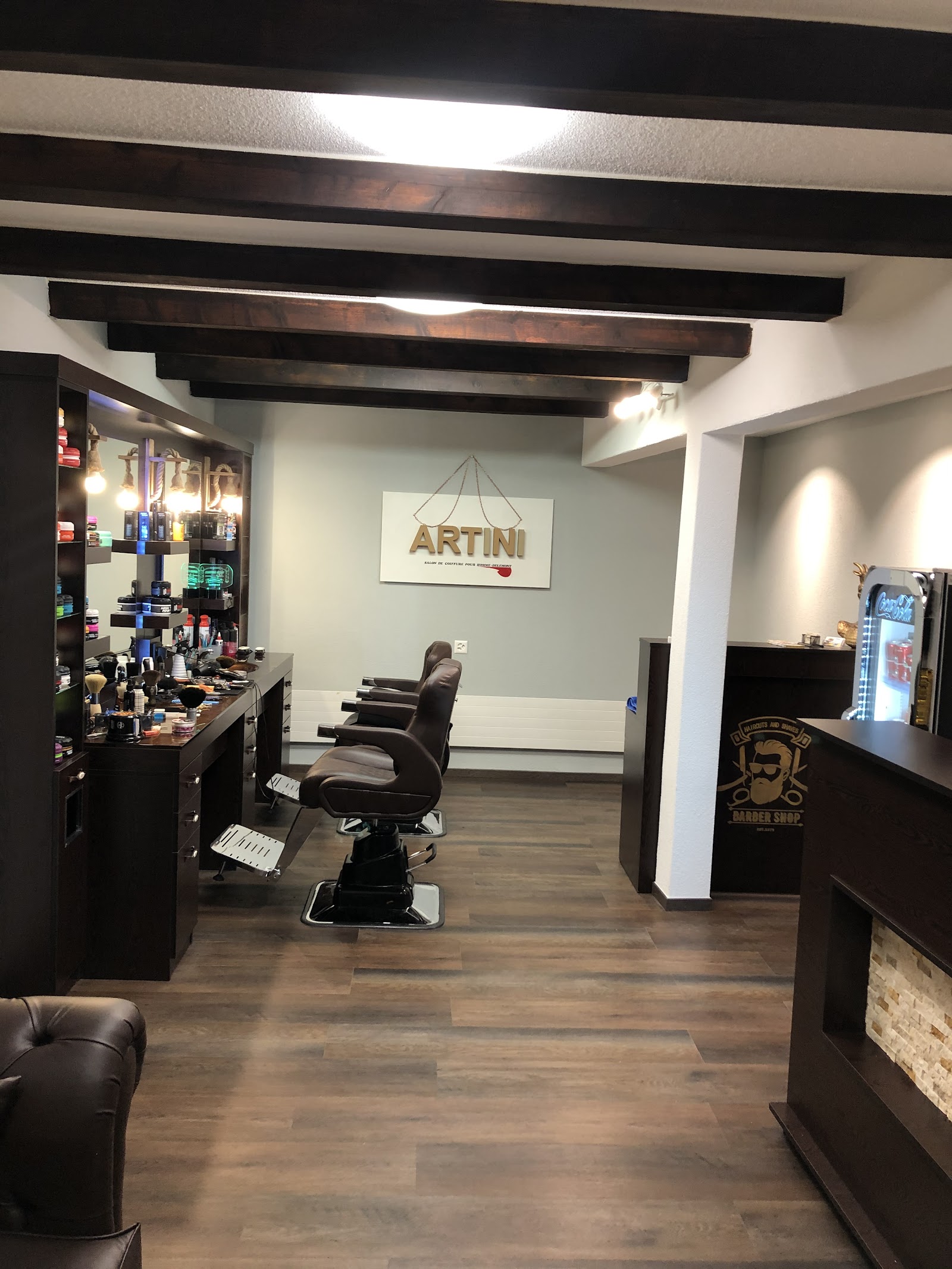 Vue d'ensemble du salon Artini — fauteuil de barbier, enseigne ARTINI et coin boissons